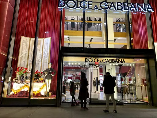 People stand outside the Dolce & Gabbana store on Fifth Avenue, Nov. 21, 2021, in New York. Dolce&Gabbana has become the first Italian fashion house to bring its beauty division in-house, a move that the CEO said Tuesday would strengthen the link between beauty and fashion, and help build inroads with younger consumers.  (AP Photo/Pamela Hassell, file)