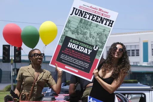 People hold a sign in their car during a car parade to mark Juneteenth on June 19, 2021, in Inglewood, Calif. Communities all over the country will be marking Juneteenth, the day that enslaved Black Americans learned they were free. For generations, the end of one of the darkest chapters in U.S. history has been recognized with joy in the form of parades, street festivals, musical performances or cookouts. Yet, the U.S. government was slow to embrace the occasion. (AP Photo/Ringo H.W. Chiu, File