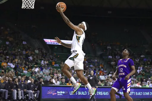 Baylor guard James Akinjo scores past Northwestern State guard Carvell Teasett, right, during the second half of an NCAA college basketball game Tuesday, Dec. 28, 2021, in Waco, Texas. (AP Photo/Rod Aydelotte)