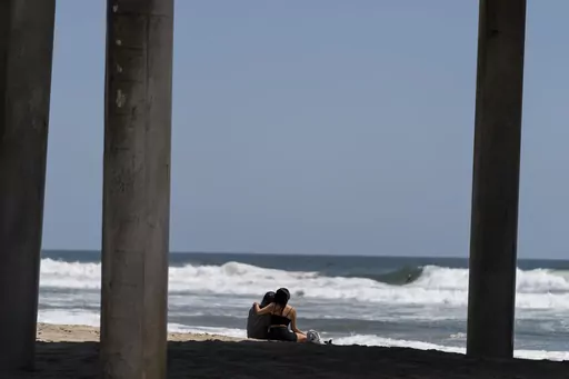 A young couple sit on the beach in Huntington Beach, Calif., Monday, May 8, 2023. For years, studies have shown a decline in the rates of American high school students having sex. That trend continued, not surprisingly, in the first years of the pandemic, according to a recent survey by the Centers for Disease Control and Prevention. The study found that 30% of teens in 2021 said they had ever had sex, down from 38% in 2019 and a huge drop from three decades ago when more than half of teens repo
