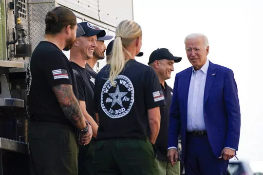 President Joe Biden greets firefighters as he tours the National Interagency Fire Center, Sept. 13, 2021, in Boise, Idaho. Biden on June 21, 2022, signed off on giving federal wildland firefighters a hefty raise for the next two fiscal years, a move that comes as much of the West is bracing for a difficult wildfire season. (AP Photo/Evan Vucci, File)