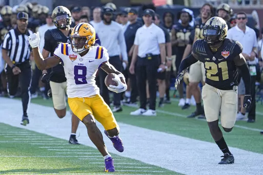 LSU wide receiver Malik Nabers (8) runs past Purdue cornerback Bryce Hampton, left, and safety Sanoussi Kane (21) on his way to a 75-yard touchdown on a pass play during the second half of the Citrus Bowl NCAA college football game Monday, Jan. 2, 2023, in Orlando, Fla. (AP Photo/John Raoux)