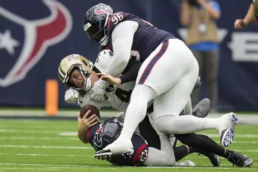 New Orleans Saints quarterback Derek Carr (4) is sacked by Houston Texans defensive tackle Maliek Collins (96) and defensive end Jonathan Greenard (52) in the second half of an NFL football game in Houston, Sunday, Oct. 15, 2023. (AP Photo/Eric Christian Smith)