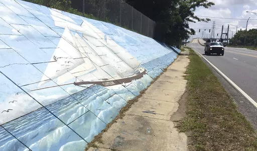 Traffic passes a mural of the slave ship Clotilda along Africatown Boulevard, in Mobile, Ala., May 30, 2019. Researchers are returning to the Alabama coast near Mobile in May 2022 to assess the sunken remains of the Clotilda, which was the last slave ship to bring captive Africans to the United States more than 160 years earlier. (AP Photo/Kevin McGill, File)