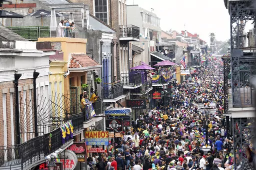 In this Feb. 25, 2020, file photo, crowds are seen packing Bourbon Street on Mardi Gras day in New Orleans. New Orleans will reinstitute an indoor mask mandate to fight the spread of COVID-19 while readying for an influx of visitors for the Mardi Gras season, the city health director said Tuesday, Jan. 11, 2022. Dr. Jennifer Avegno said the mandate takes effect Wednesday at 6 a.m. and will apply to participants in the annual Mardi Gras balls that take place in the city. (AP Photo/Rusty Costanza,