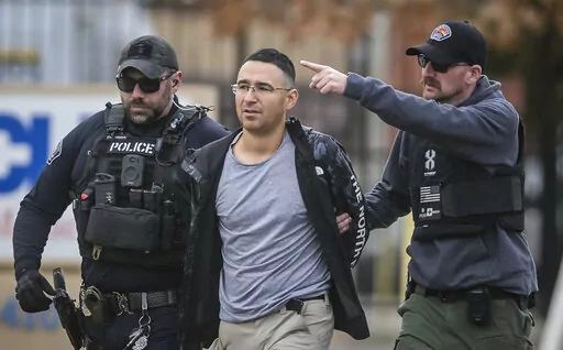 Solomon Pena, center, a Republican candidate for New Mexico House District 14, is taken into custody by Albuquerque Police officers, Jan. 16, 2023, in southwest Albuquerque, N.M. Two years since the attack on the U.S. Capitol, a series of drive-by shootings targeting Democrats in New Mexico is a violent reminder that the false claims about a stolen election persist in posing a danger to public officials and the country’s democratic institutions. No one was hurt in the Albuquerque attacks. (Rob