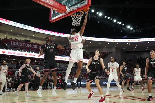 Houston forward J'Wan Roberts (13) shoots during the second half of an NCAA college basketball game against Troy in Houston, Tuesday, Dec. 10, 2024. (AP Photo/Ashley Landis)