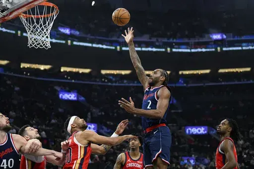 Los Angeles Clippers forward Kawhi Leonard (2) shoots over New Orleans Pelicans forward Bruce Brown, center, during the first half of an NBA basketball game Wednesday, April 2, 2025, in Inglewood, Calif. (AP Photo/William Liang)