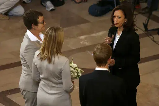 Attorney General Kamala Harris, right, officiates the wedding of Kris Perry, from left, and Sandy Stier, in San Francisco, June 28, 2013. (AP Photo/Jeff Chiu, File)