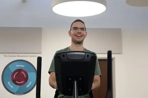 Jacob Bullard warms up on an elliptical machine while undergoing physical therapy at WashU, Monday, Dec. 16, 2024, in St. Louis. (AP Photo/Jeff Roberson)